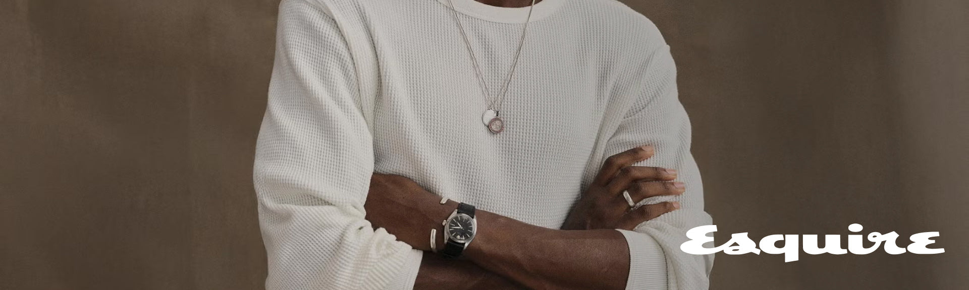 Close-up of a man's wrist wearing a watch over a waffle-knit thermal sleeve, next to the Esquire logo