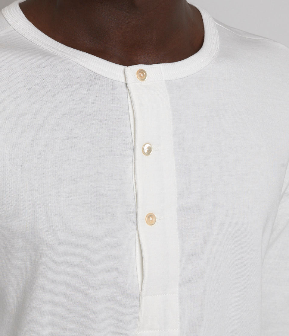 Close-up of a white henley shirt with buttons.