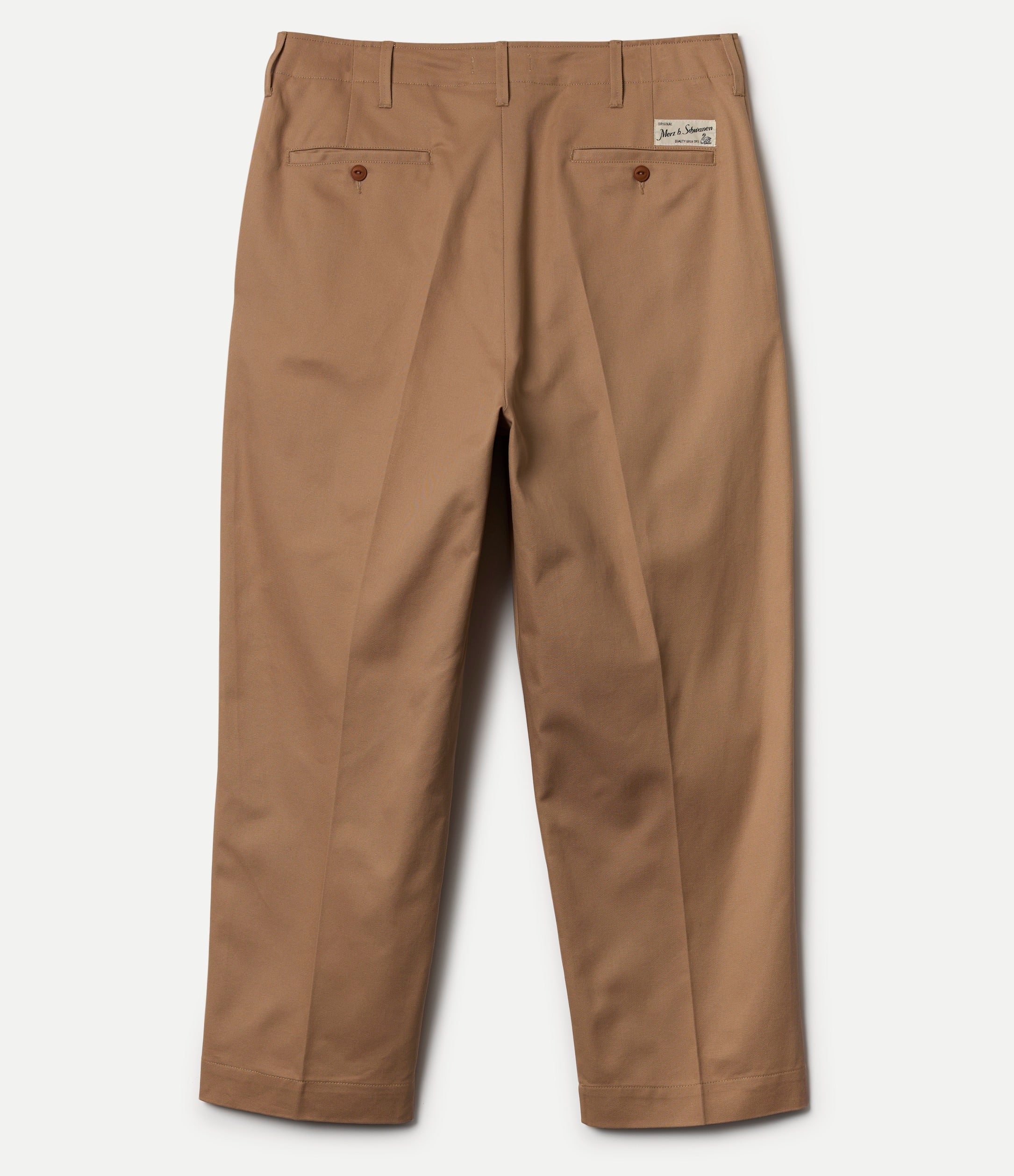 Brown chinos with a visible brand label on a white background