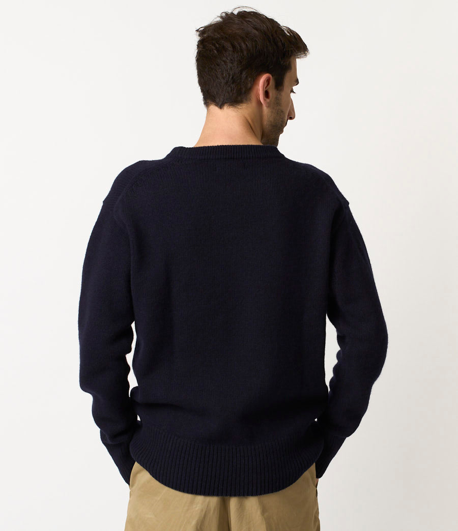 Man wearing a navy sweater against a white background