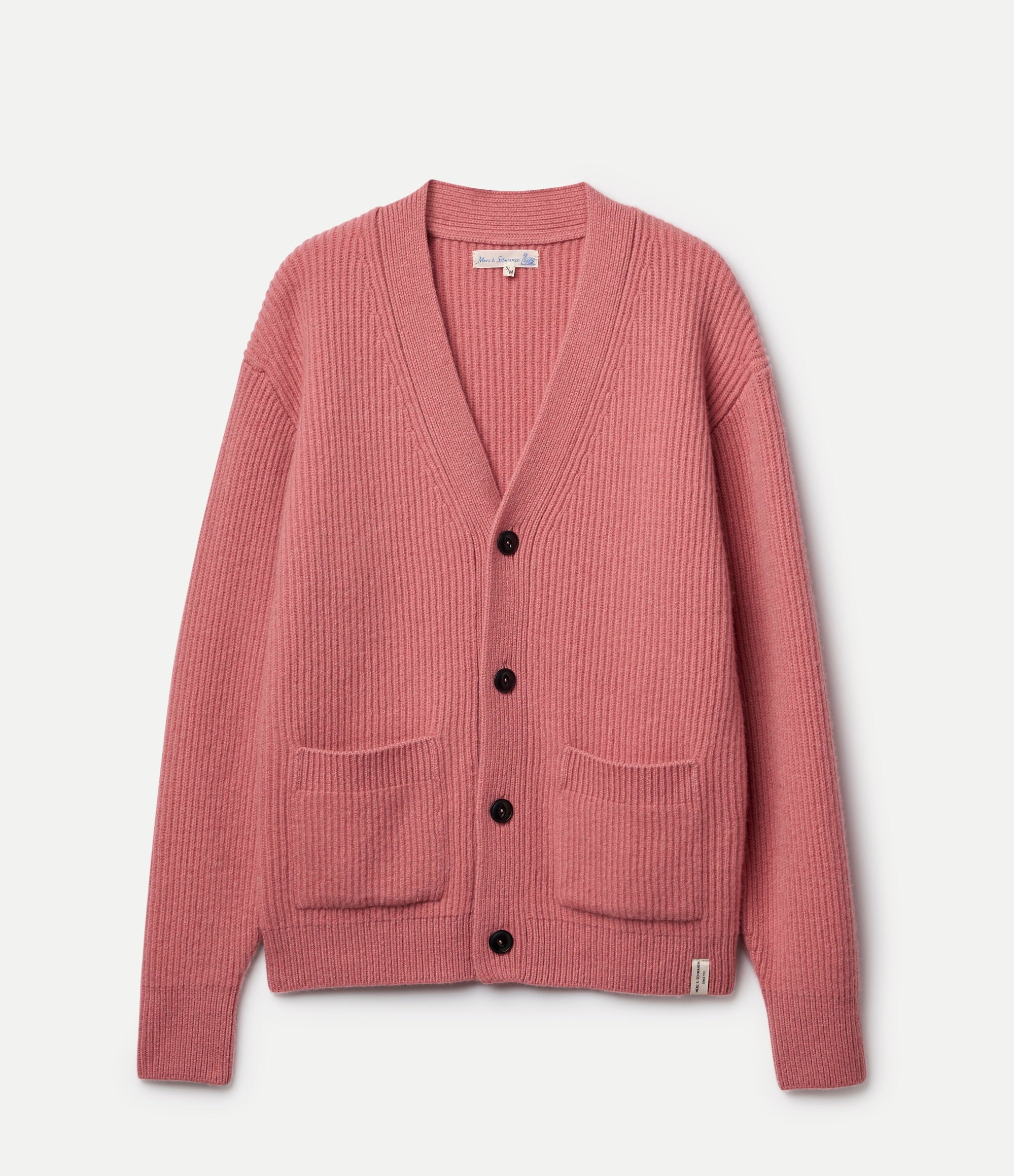 Pink cardigan with black buttons on a light pink background