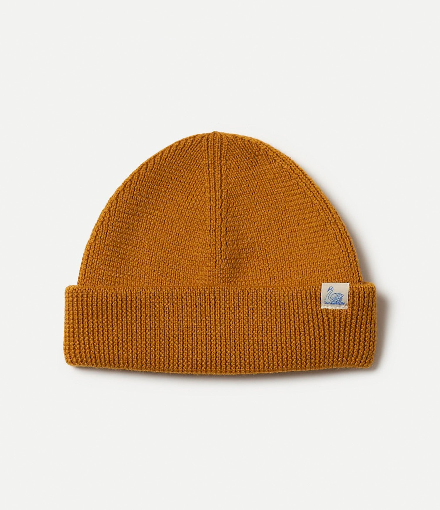 Honey Brown knit beanie with a Swan logo tag on a light gray background