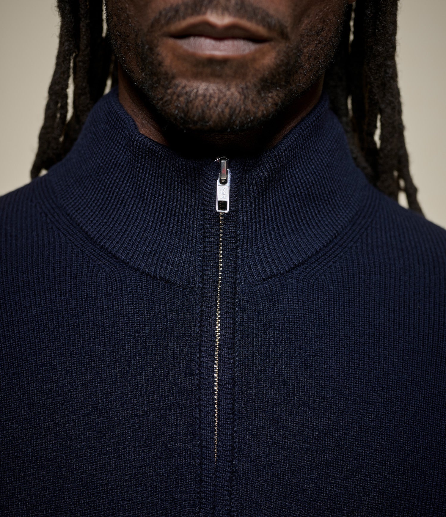 Navy blue zip-up sweater worn by a person  against a neutral background