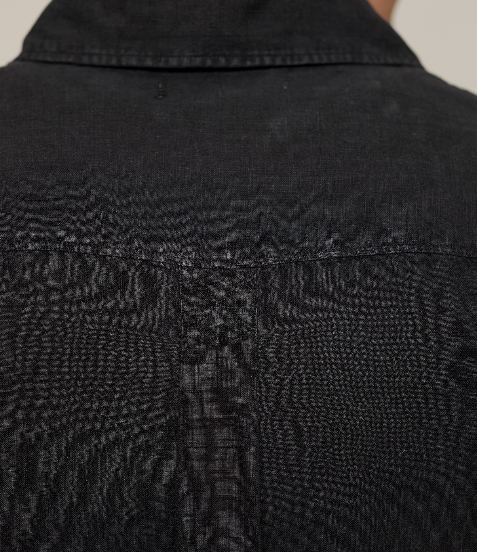 Close-up of a black linen shirt with a neutral background