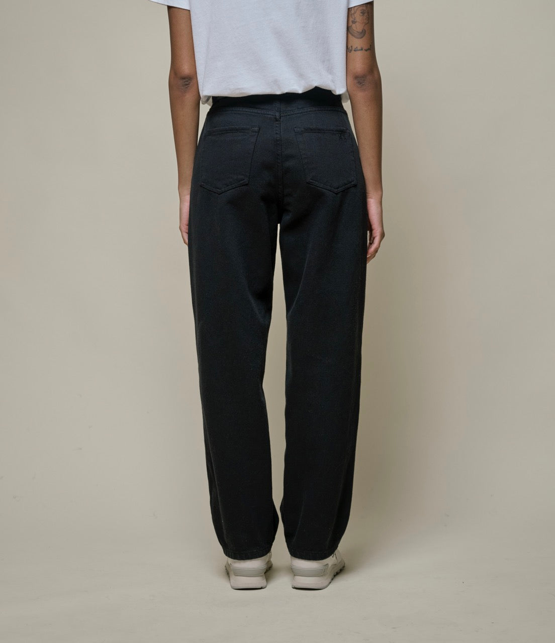 Backside of person wearing black pants and white T-shirt