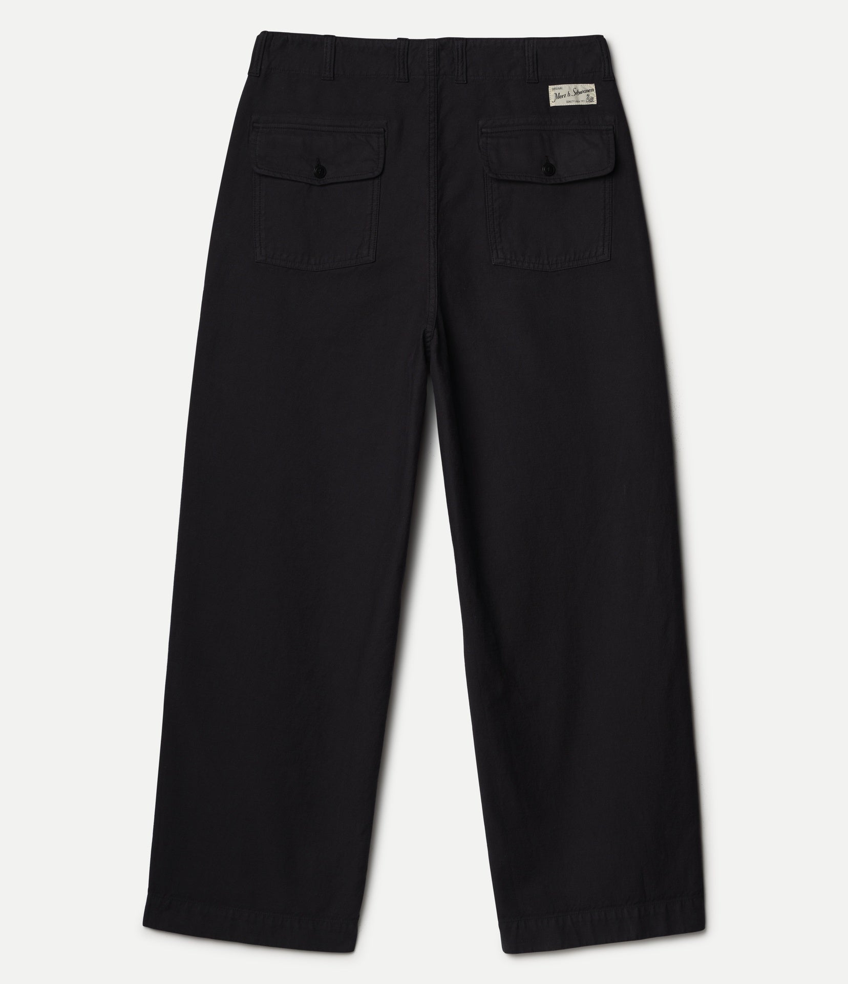 Black pants shown from behind with two back pockets and a Merz b. Schwanen label on a white surface