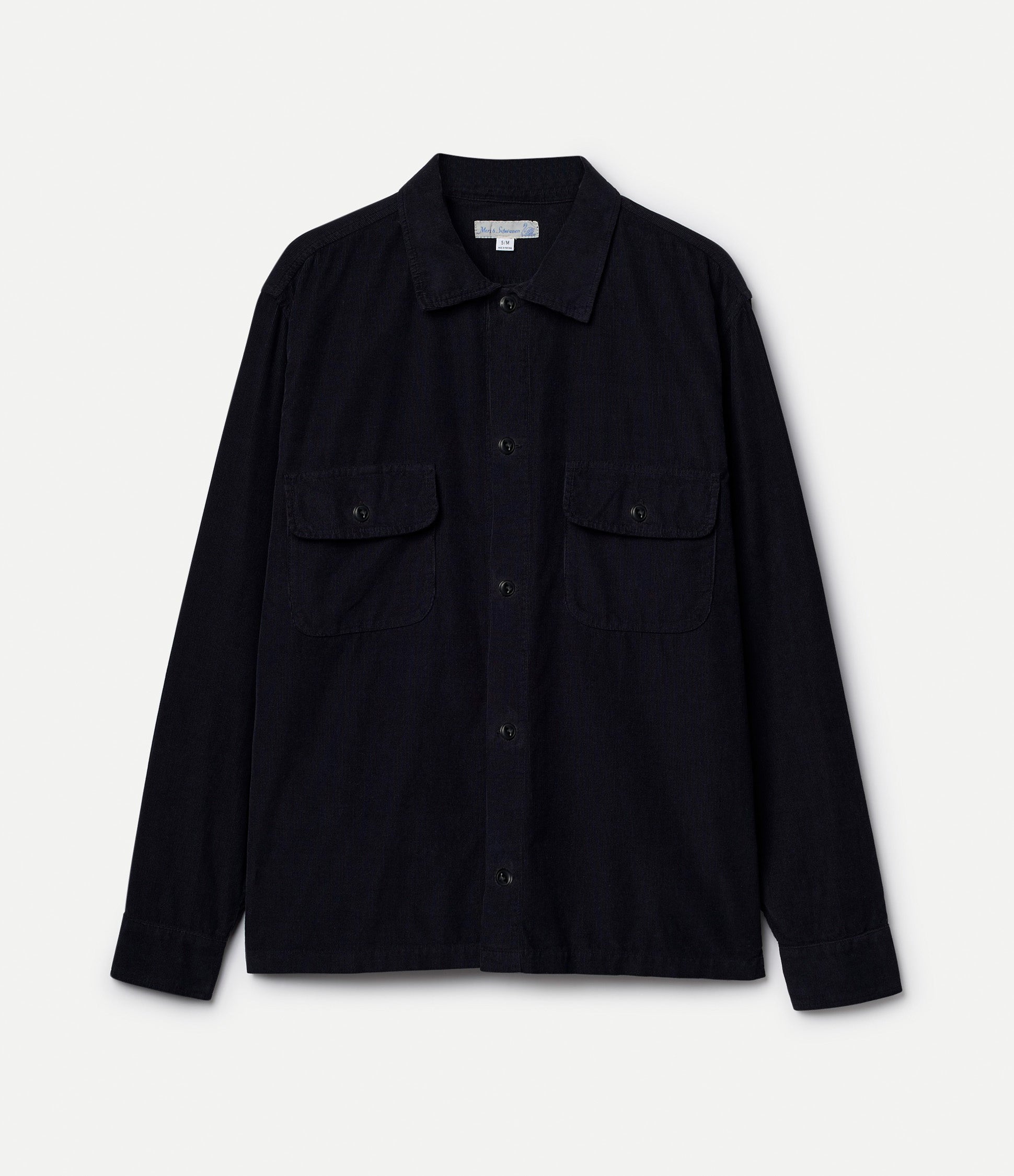 Black corduroy shirt with black buttons on a light gray background