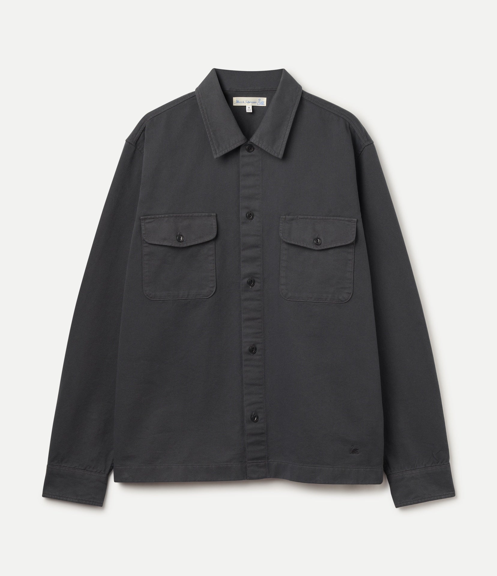 A dark charcoal gray long-sleeve button-up shirt jacket with two buttoned chest flap pockets, displayed flat against a light off-white background.